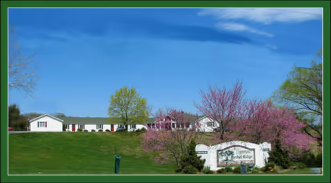 Exterior view of Bethel Ridge Assisted Living with a green lawn, trees, and a sign.