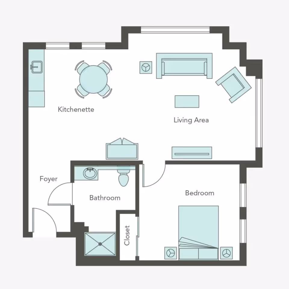 Floor plan of a living space at Aegis Living Ballard showing a kitchenette with a round dining table and four chairs, a living area with a sofa, armchair, coffee table, and side table, a bedroom with a bed and two nightstands, a bathroom with a sink, toilet, and shower, a closet, and a foyer at the entrance.