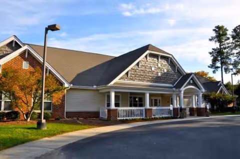 Single-story assisted living facility with brick facade, covered entrance, and a manicured lawn.