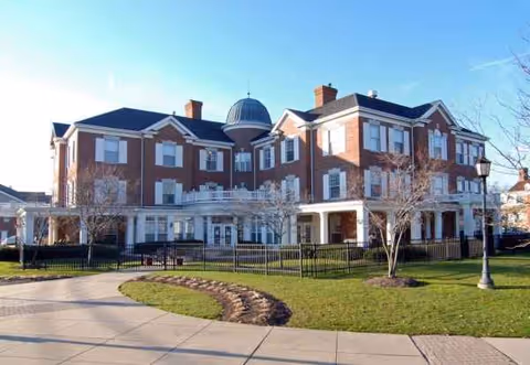 Exterior shot of The Woodlands of Shaker Heights with brick building, dome, and lawn.