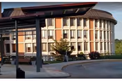 Curved brick senior living building with large windows and a circular driveway.