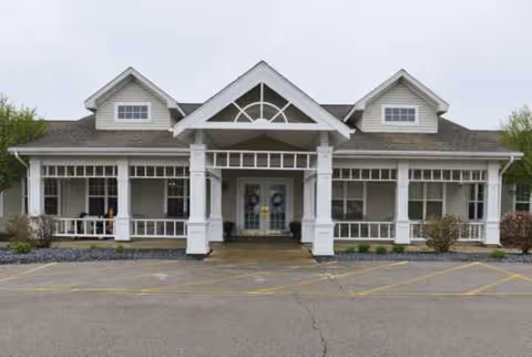 Front view of a white senior living facility with a central entry and porch.