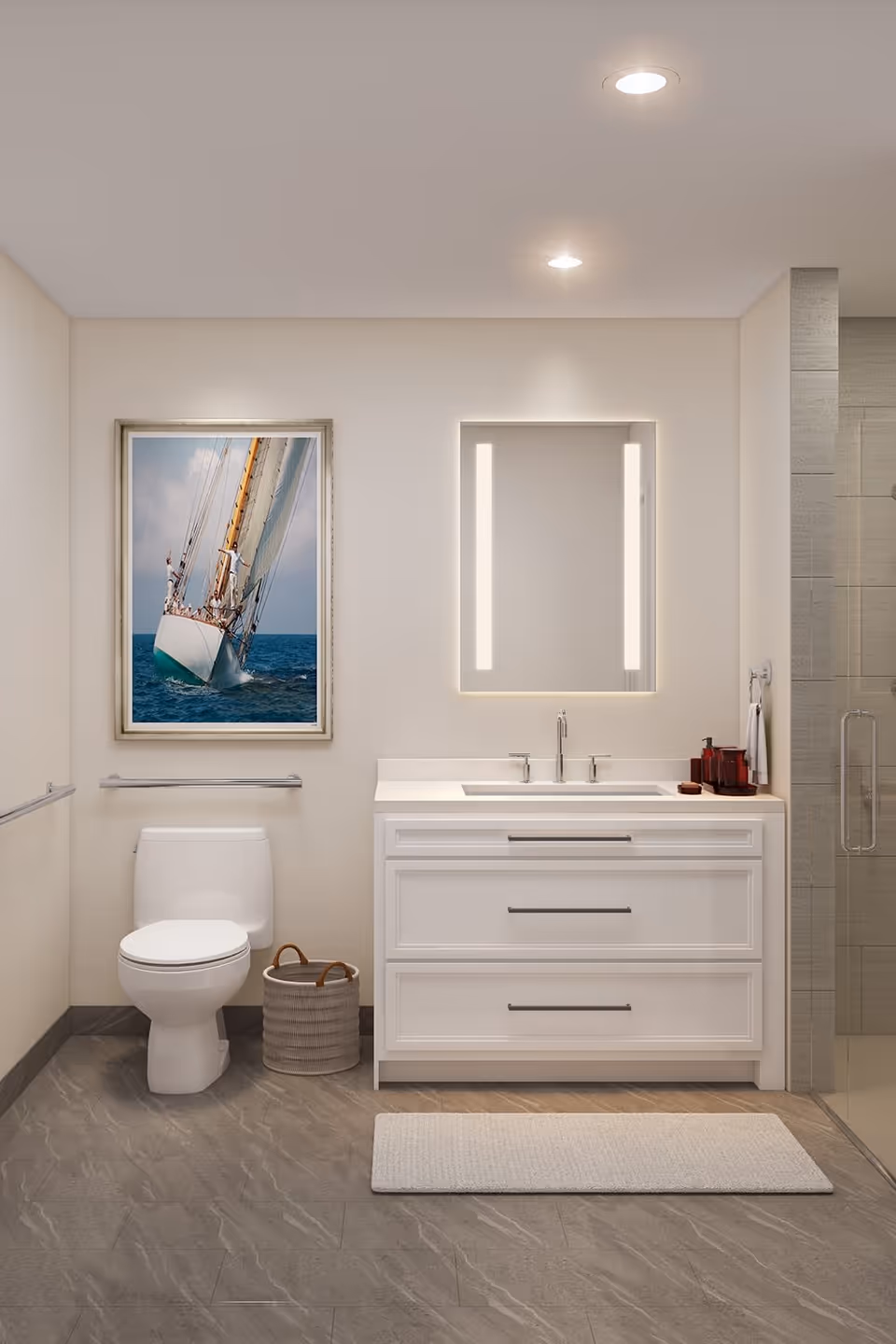 A modern bathroom featuring a white toilet, a white vanity with two drawers and a sink, a rectangular mirror with vertical lights on each side, a wicker basket on the floor, a framed picture of a sailboat on the wall, and a glass-enclosed shower on the right.