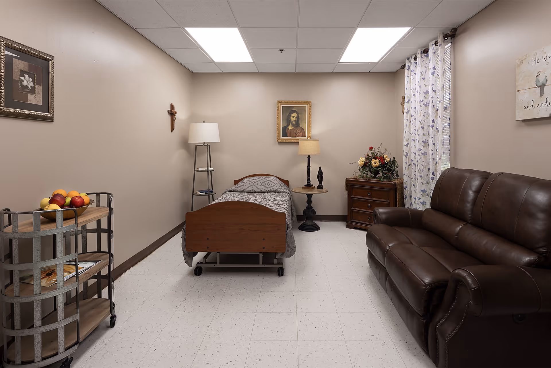 A furnished private nursing facility bedroom with a single bed, leather sofa, nightstand, lamps, and wall decorations.