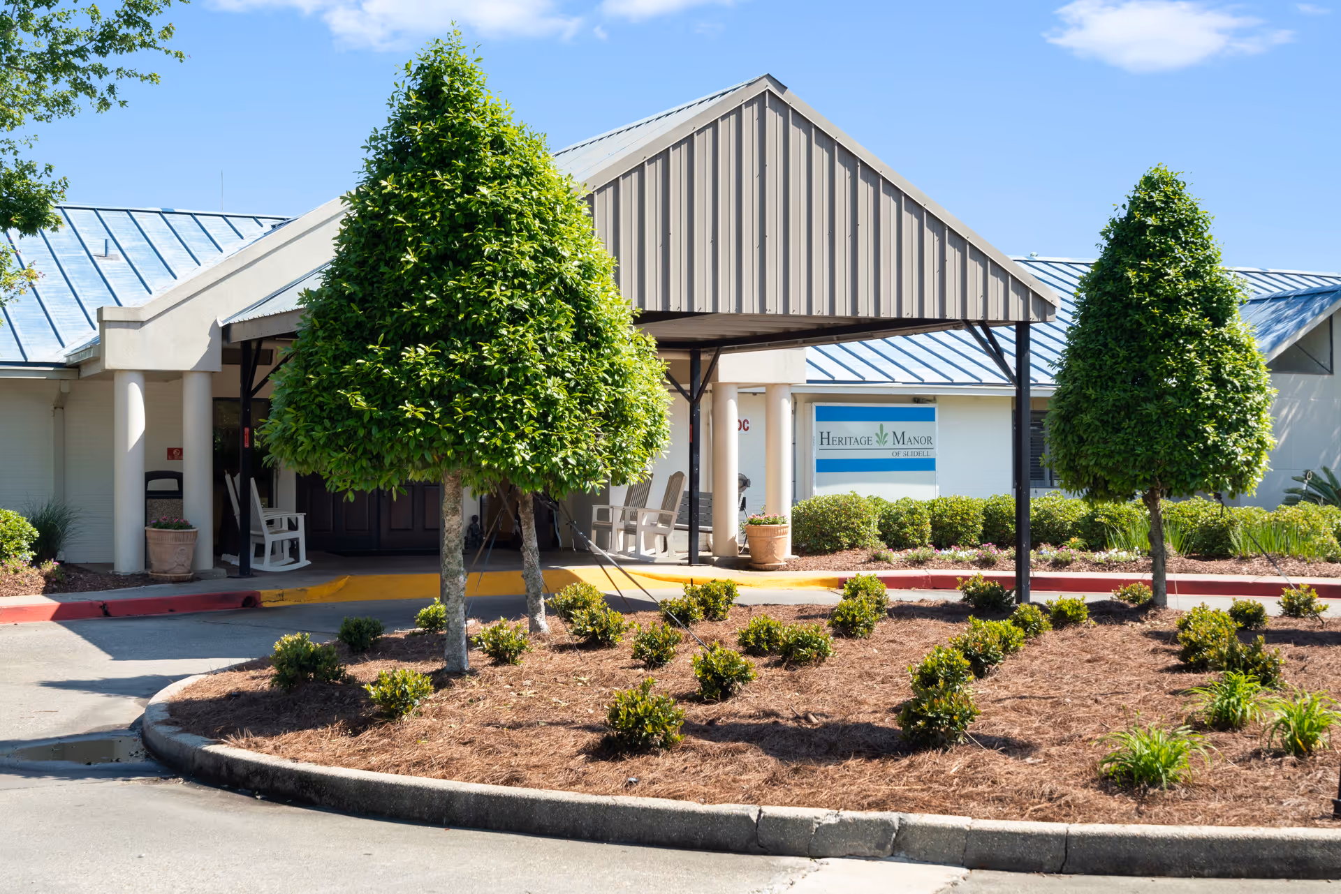 Front view of Heritage Manor Slidell showing a covered entrance and manicured landscaping.