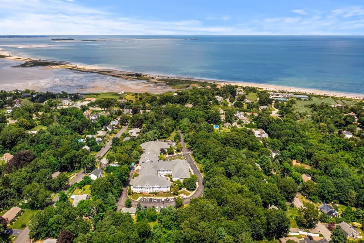 Aerial view of Sunrise of Plymouth Beach campus surrounded by trees and coastline.