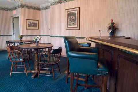 Inside a senior living facility dining area with a round table and bar counter.