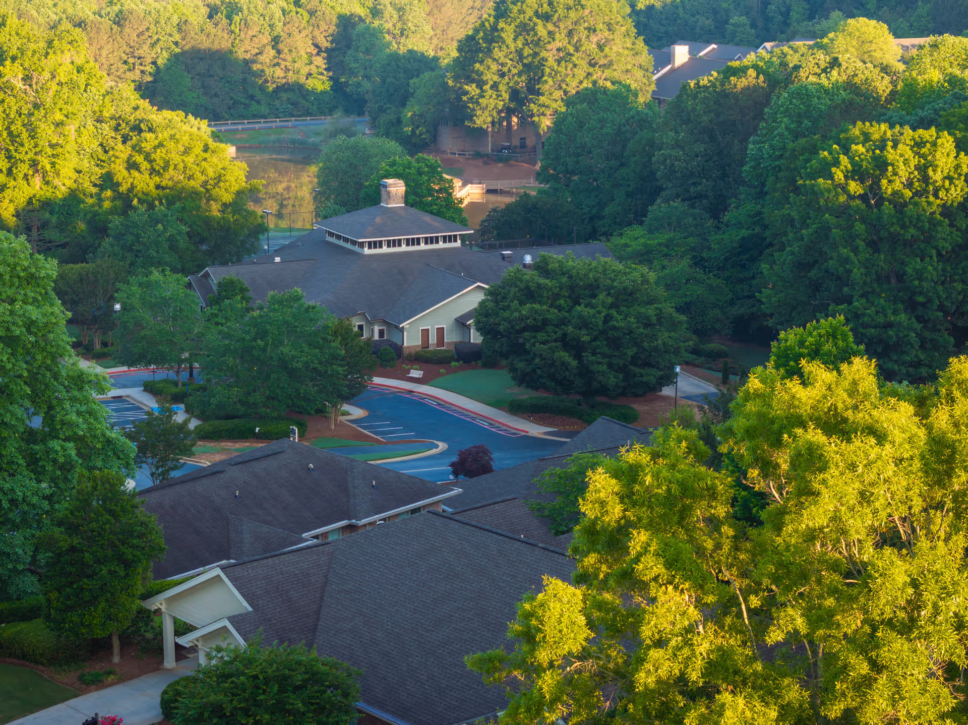 Aerial view of Presbyterian Village campus with multiple residential buildings, driveways, parking areas, and surrounding trees.