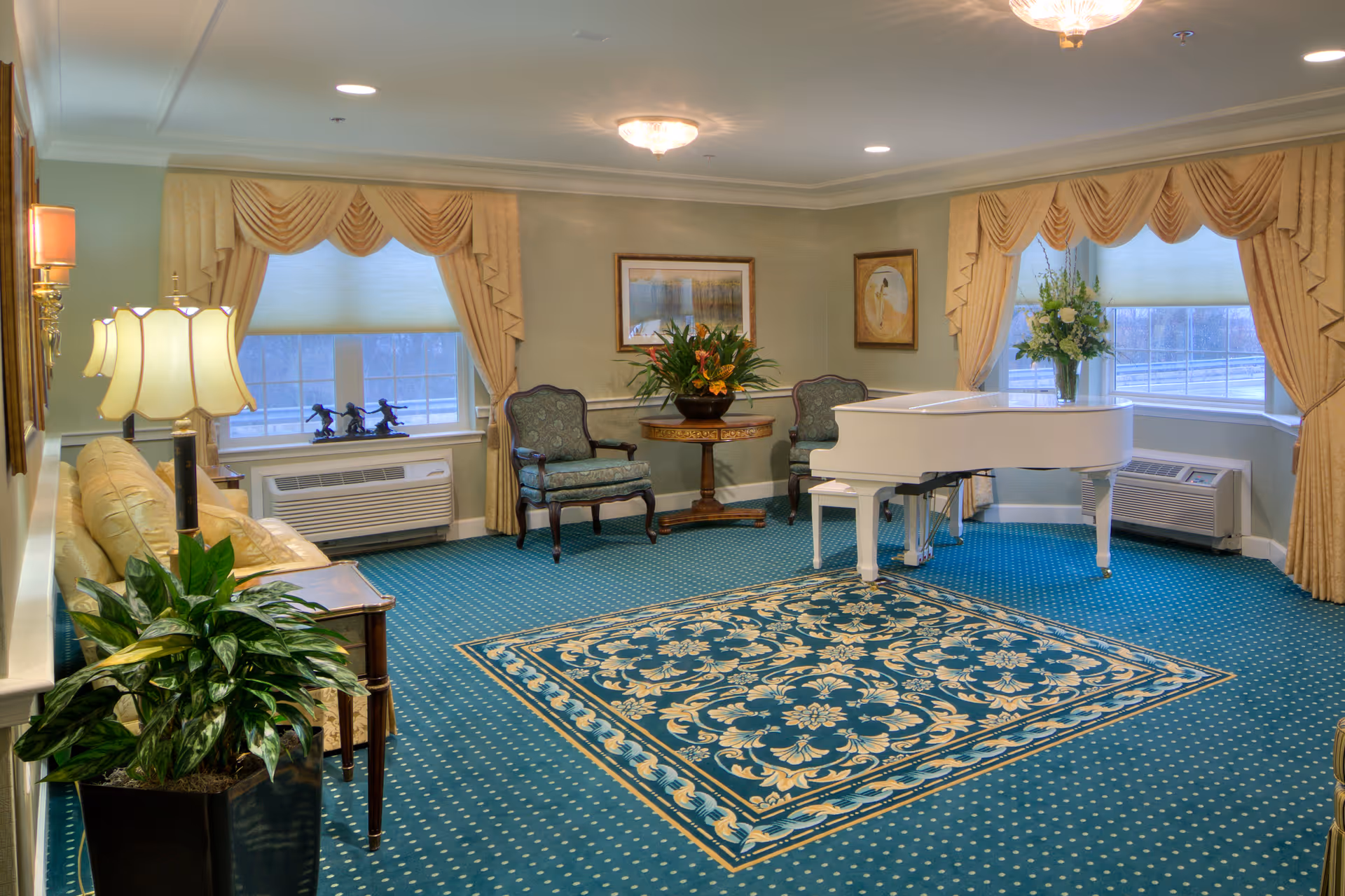 Elegant lounge with a white grand piano, seating, plants, and a patterned carpet under large curtained windows.