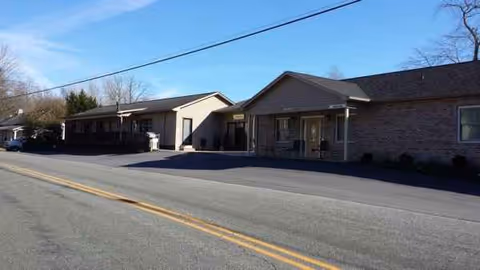An exterior view shows a single-story senior living facility along a street.