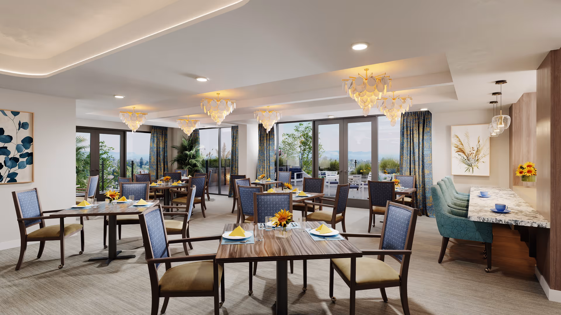 A bright and spacious dining room with multiple wooden tables and chairs arranged neatly. Each table is set with yellow napkins, plates, glasses, and small flower centerpieces. Large windows and glass doors with blue patterned curtains allow natural light to fill the room and offer a view of an outdoor patio area with additional seating. The room features modern chandeliers hanging from the ceiling and a counter area with teal upholstered chairs and blue cups.