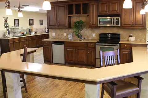 Spacious kitchen with dark wood cabinets, island, and built-in appliances.