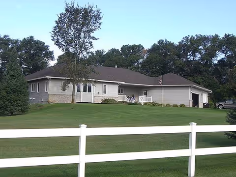 Single-story senior living facility viewed from the front with a grassy yard.