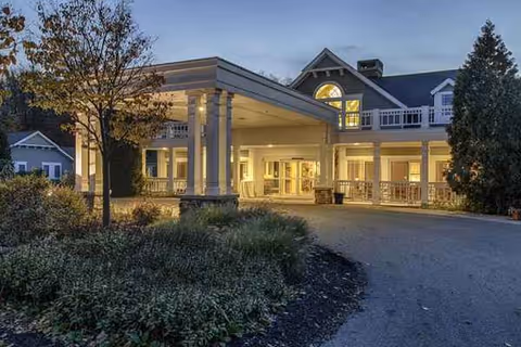 Sunset-lit entrance of Maplewood at Chardon with a covered drop-off and columns.