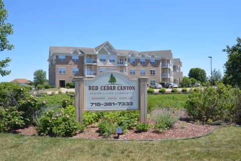 Exterior view of a multi-story senior living building with Red Cedar Canyon sign.
