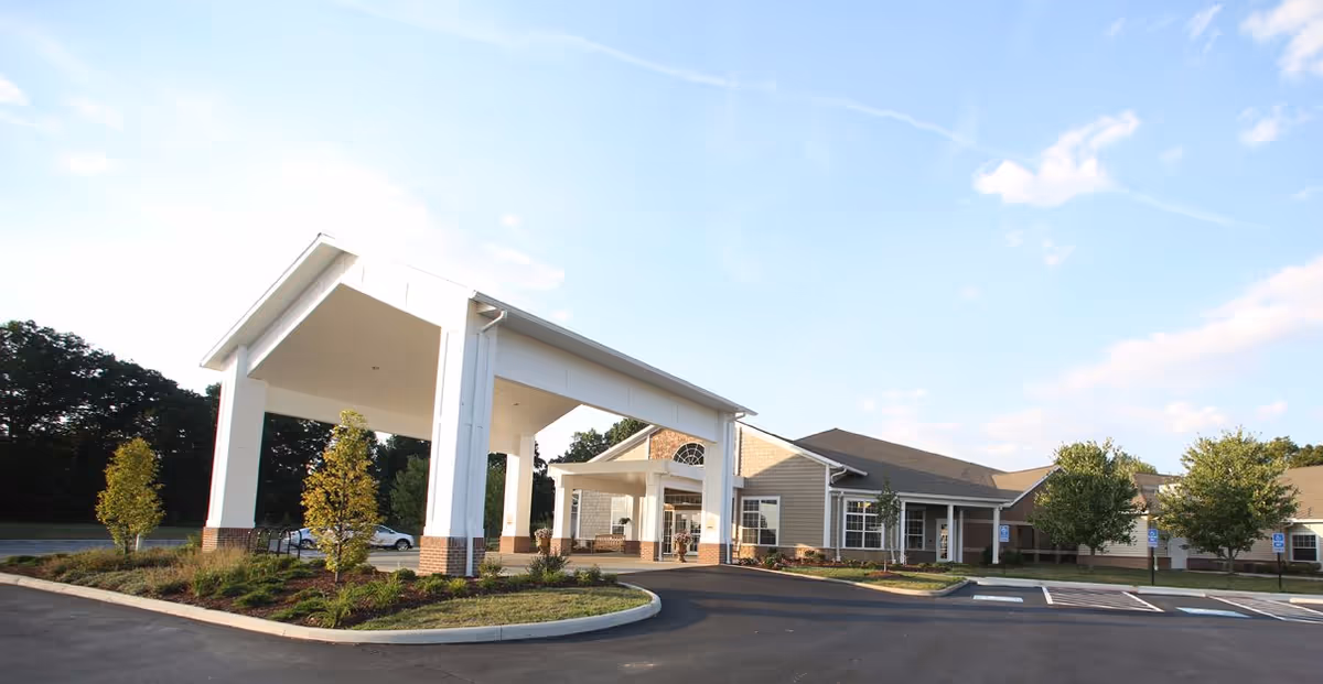 Exterior view of Danbury Massillon senior living facility entrance with porte-cochere and landscaping.