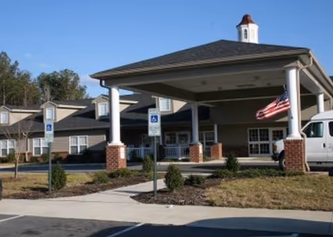 Front view of Rich Square Manor entrance with portico, handicap parking, and American flag.