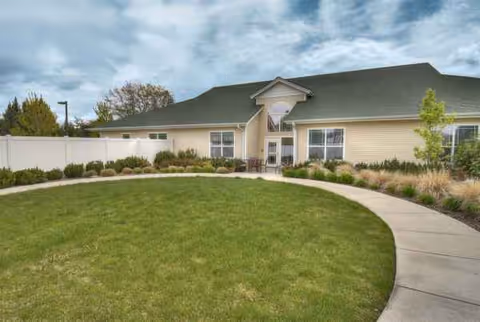 Front exterior of Emerson House at Riverpointe, a single-story senior living facility with curved walkway.