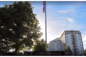 Exterior view of Capital Manor Retirement Community building with flagpole and large tree.
