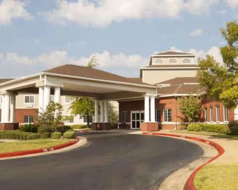 Exterior view of Garden Estates of Tyler with driveway, porte-cochere, and landscaped entrance.