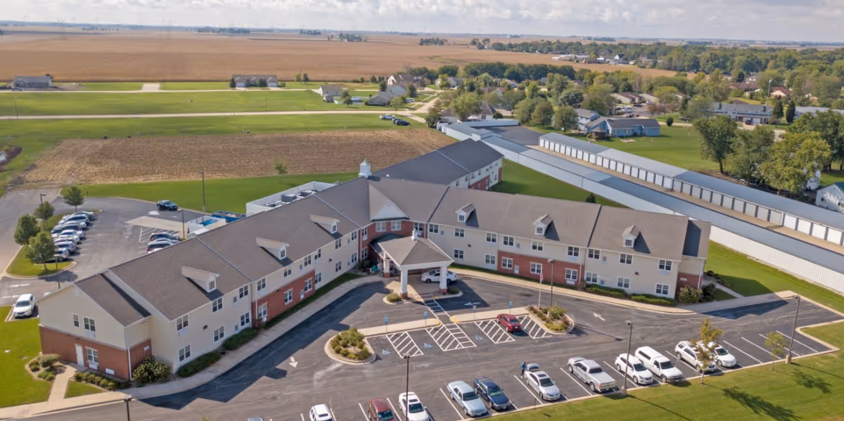 Aerial view of Heritage Woods of Dwight senior living campus with parking and surrounding fields.