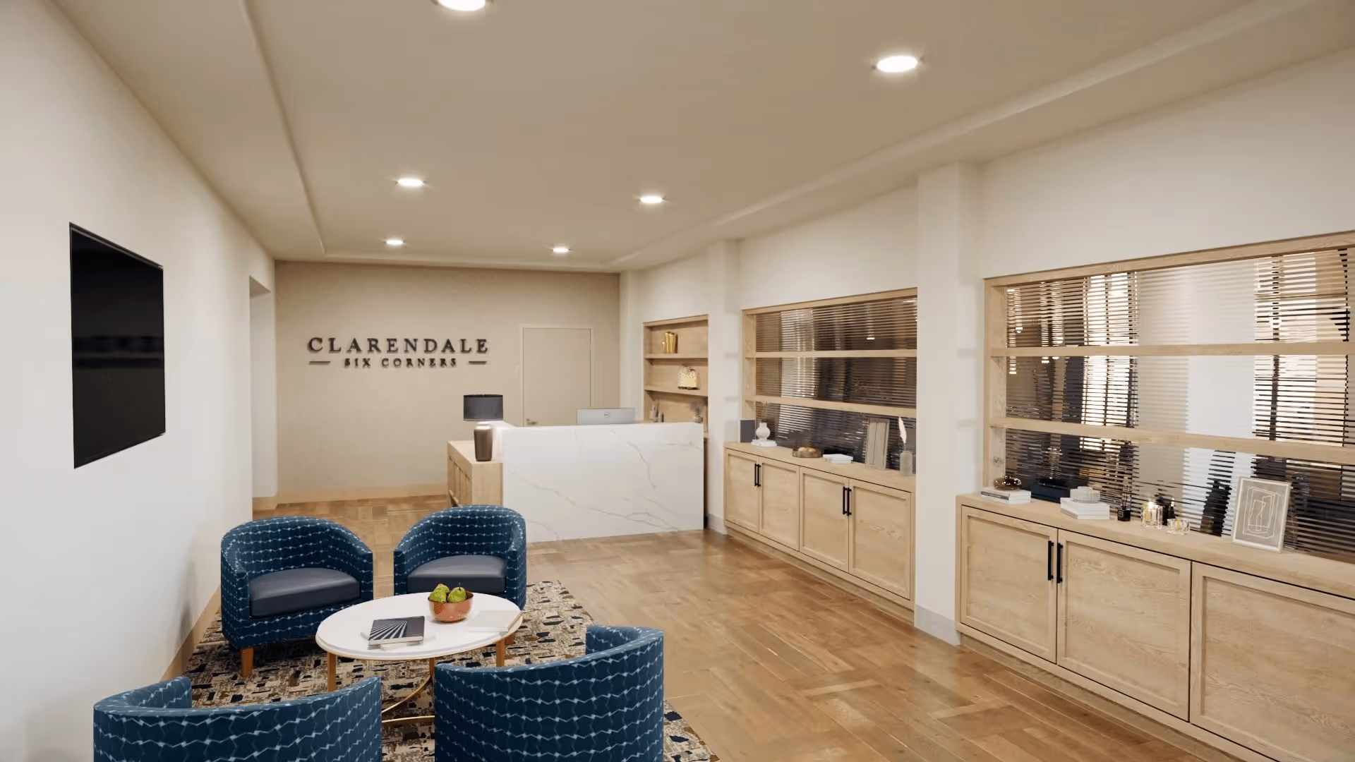 Reception lobby with a marble front desk, blue seating around a coffee table, and a wall sign reading "Clarendale Six Corners".
