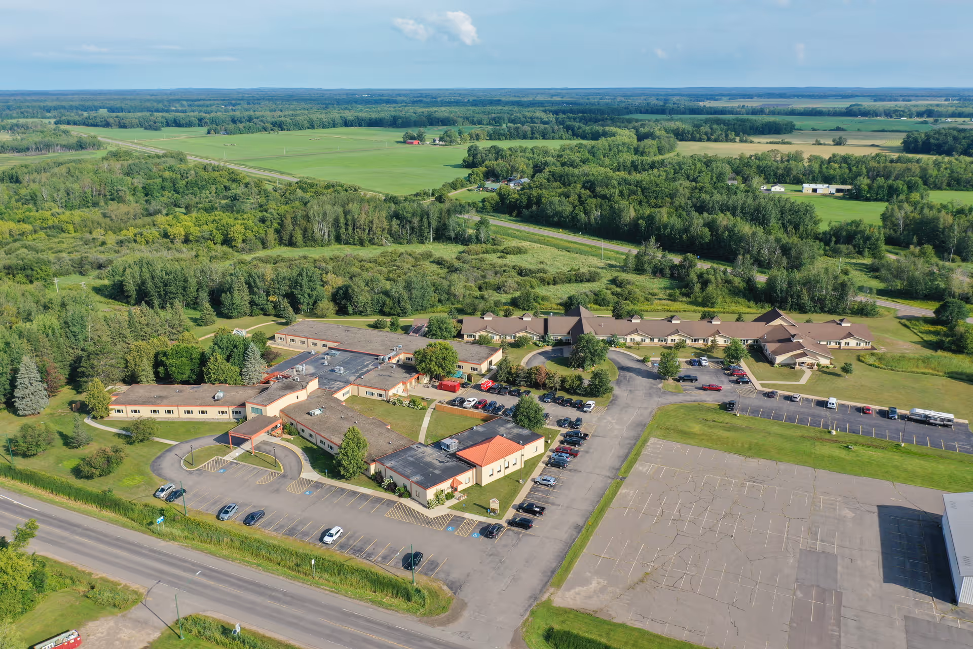 Aerial view of Aicota Health Care Center showing the single-story facility, parking lot, and surrounding green fields.