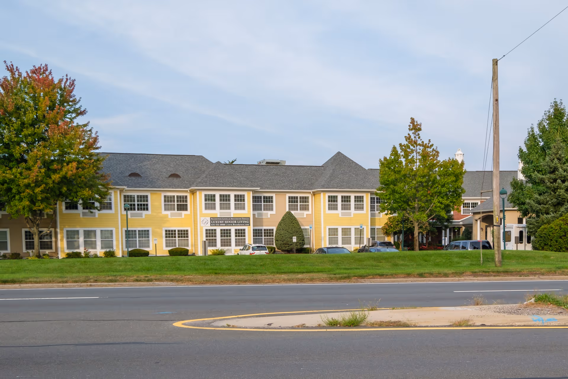 Exterior view of the Brandywine Huntington Terrace senior living facility with landscaped trees.