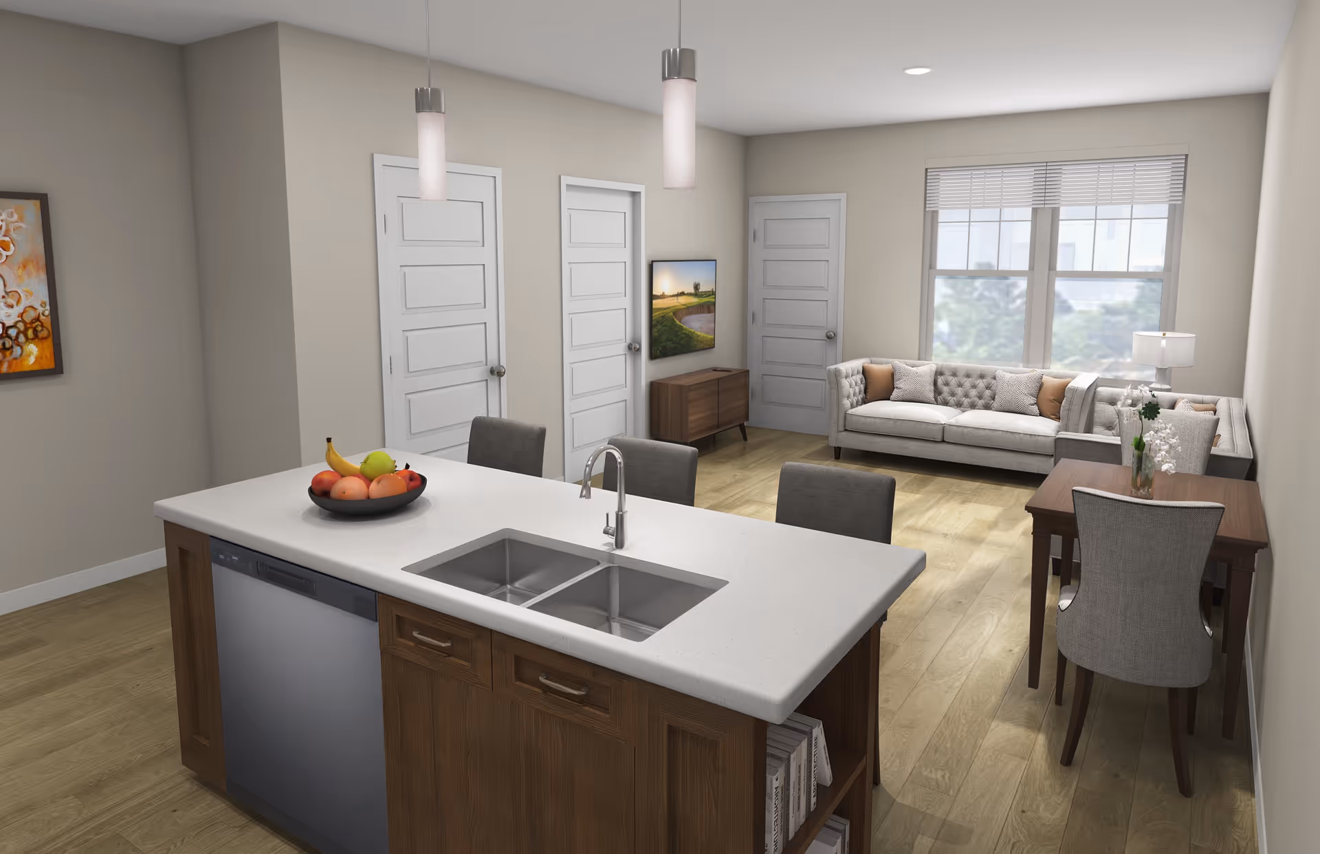 A modern open-concept living space featuring a kitchen island with a double sink and a bowl of fruit, three gray chairs, a dining table with two upholstered chairs, a corner sofa with cushions, a small wooden cabinet with a TV mounted above it, and three white doors along the back wall. The room has light wood flooring, beige walls, and a window with blinds letting in natural light.