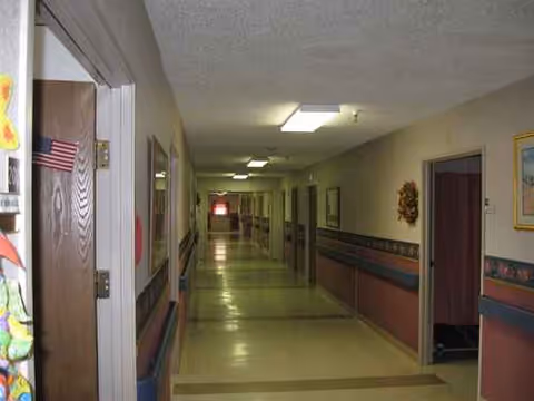 Long indoor hallway in a senior living facility with doors along both sides.