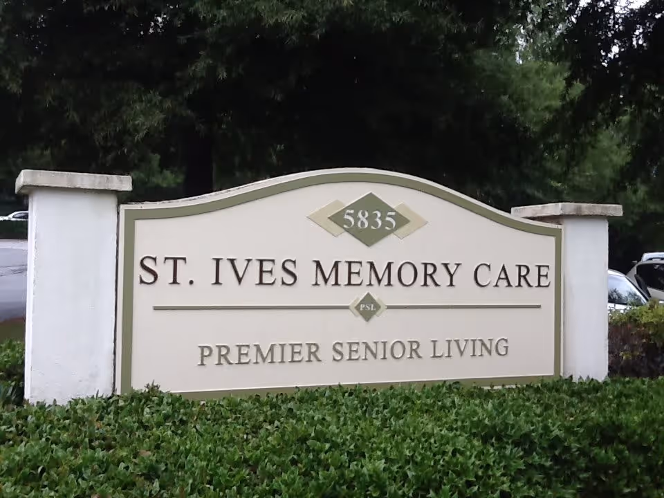 Outdoor sign for St. Ives Memory Care, a premier senior living facility, with the address number 5835 displayed above the name. The sign is surrounded by greenery and trees in the background.