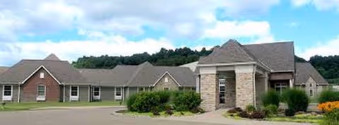 A single-story senior living campus with brick-and-stone exterior and central entrance.