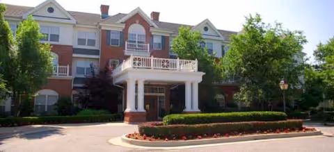 Exterior view of The Grove at Midtown, brick building with a covered entrance and manicured landscaping.