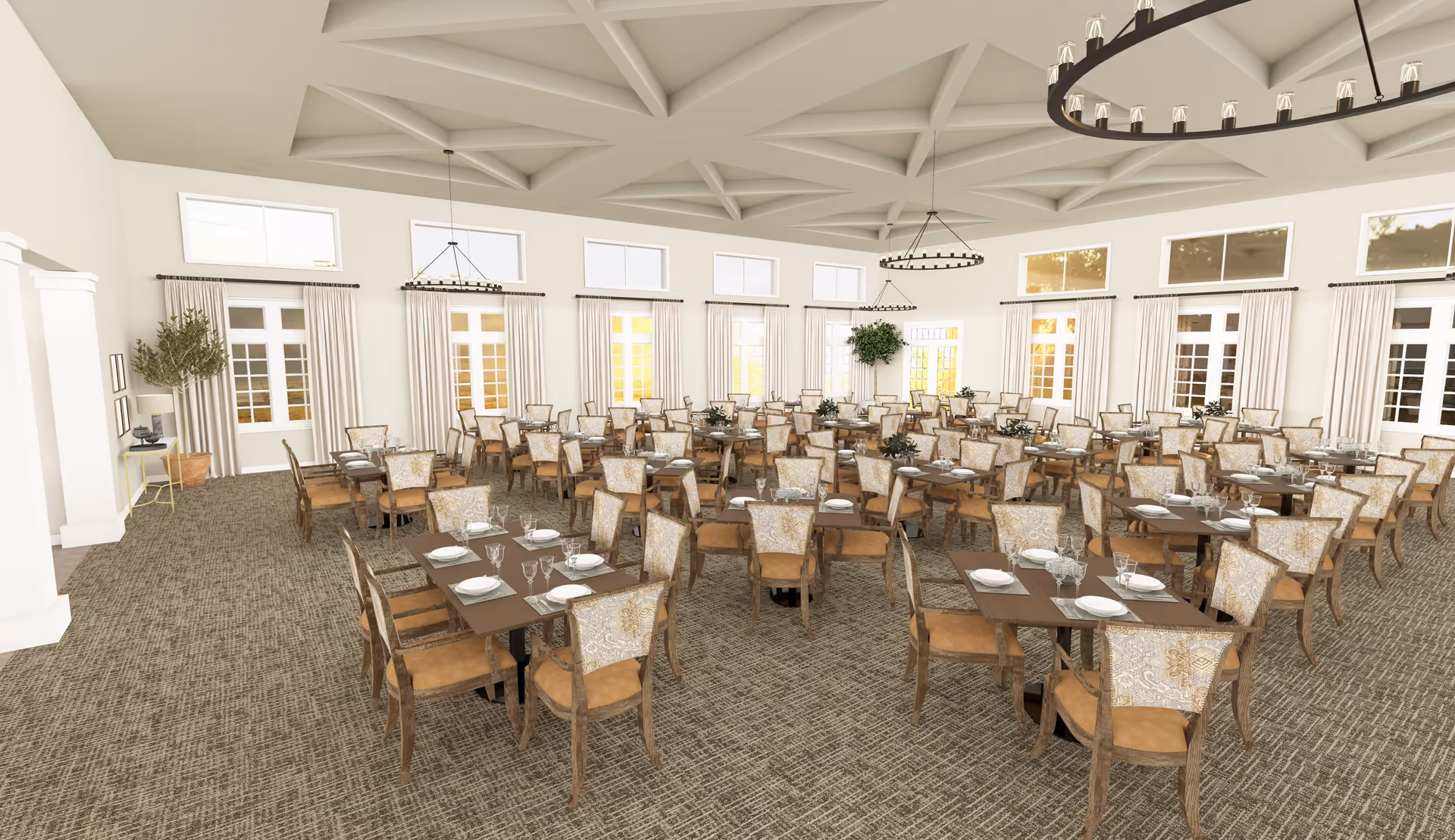 Spacious dining room with multiple wooden tables and upholstered chairs arranged neatly. Each table is set with plates, glasses, and silverware. The room features large windows with white curtains, high ceilings with decorative beams, and two large circular chandeliers. There are potted plants placed near the walls, adding greenery to the bright and airy space.