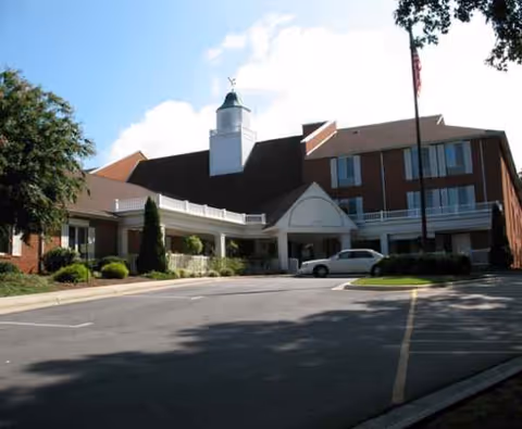 Exterior view of Kingston Residence of Hickory showing entrance arch and parking.