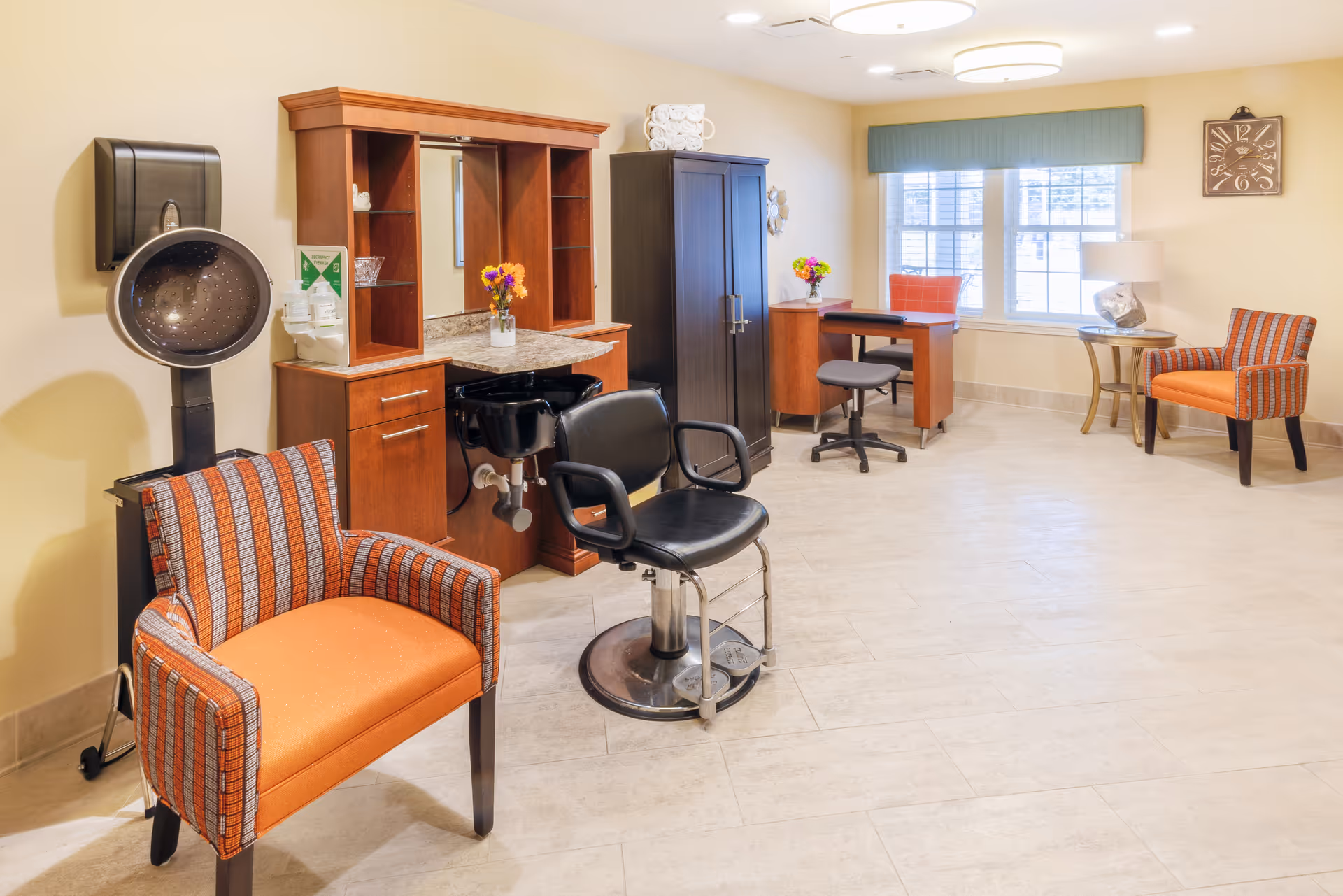 Well-lit salon area with a styling chair, hooded hair dryer, wooden cabinetry and orange upholstered chairs.