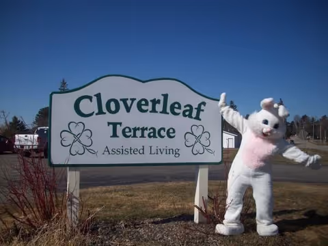 Cloverleaf Terrace Assisted Living sign with a white bunny statue outdoors