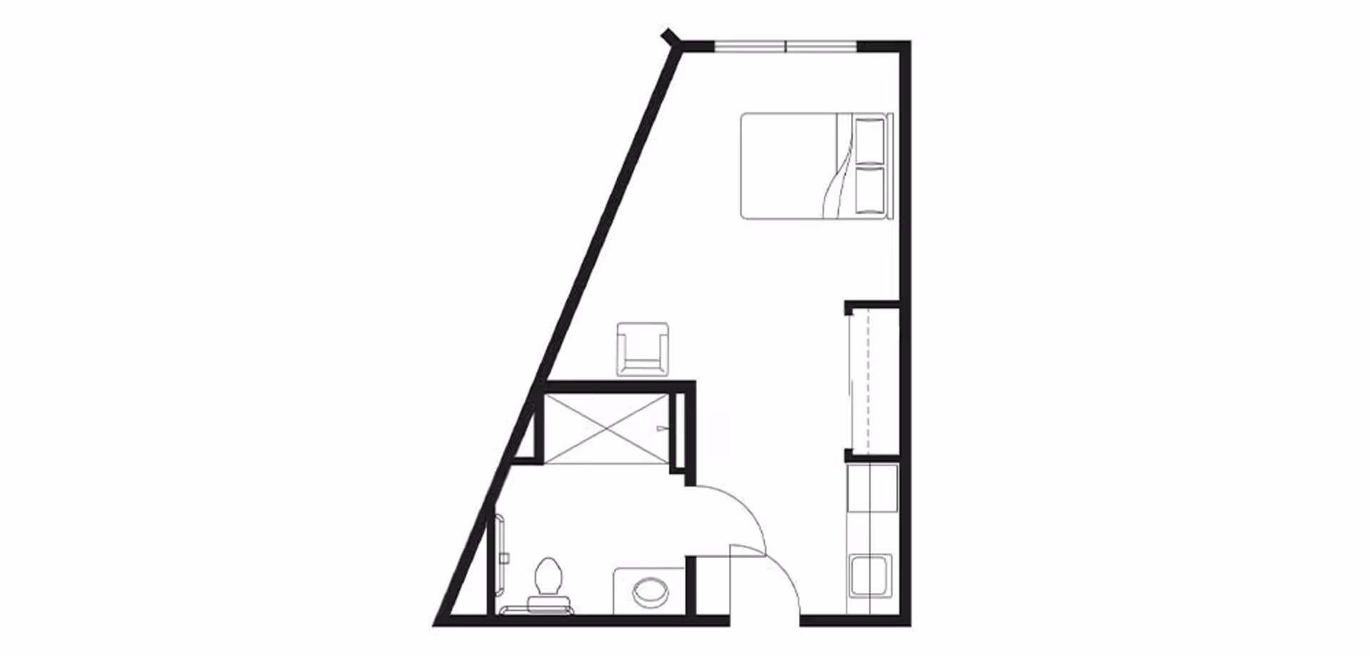 Floor plan of a studio apartment featuring a combined sleeping and living area with a bed, chair, and kitchenette, along with a separate bathroom containing a toilet and shower.