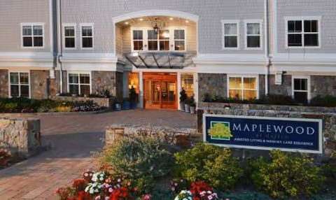 Front exterior of Maplewood Senior Living with entrance, landscaping, and Maplewood sign.