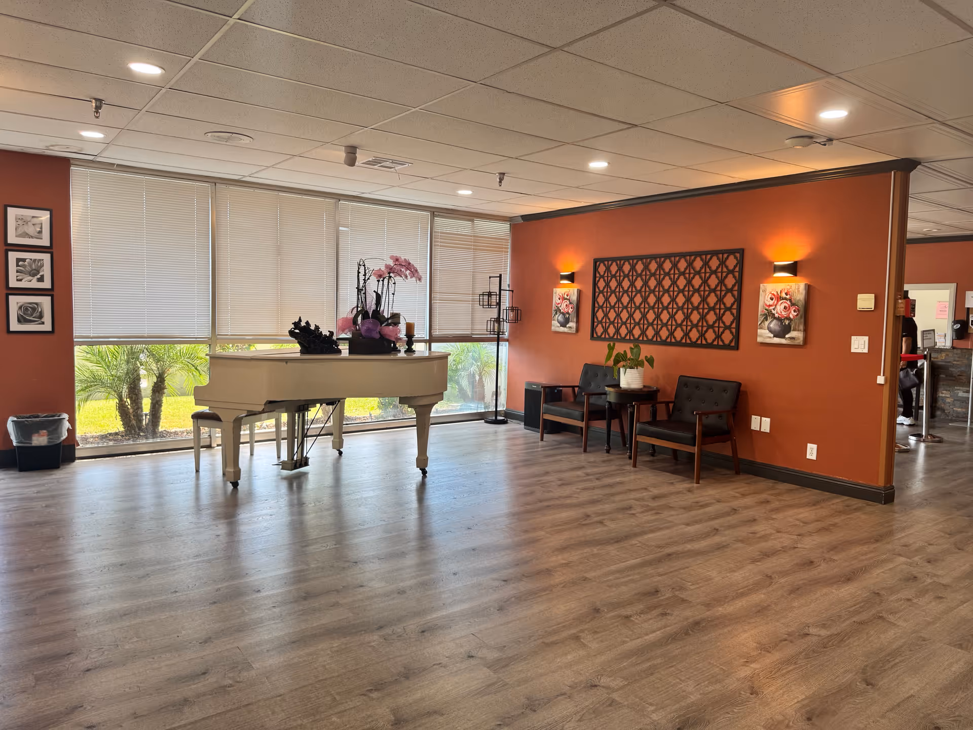 A welcoming interior space with a white piano, seating, and decorative elements.