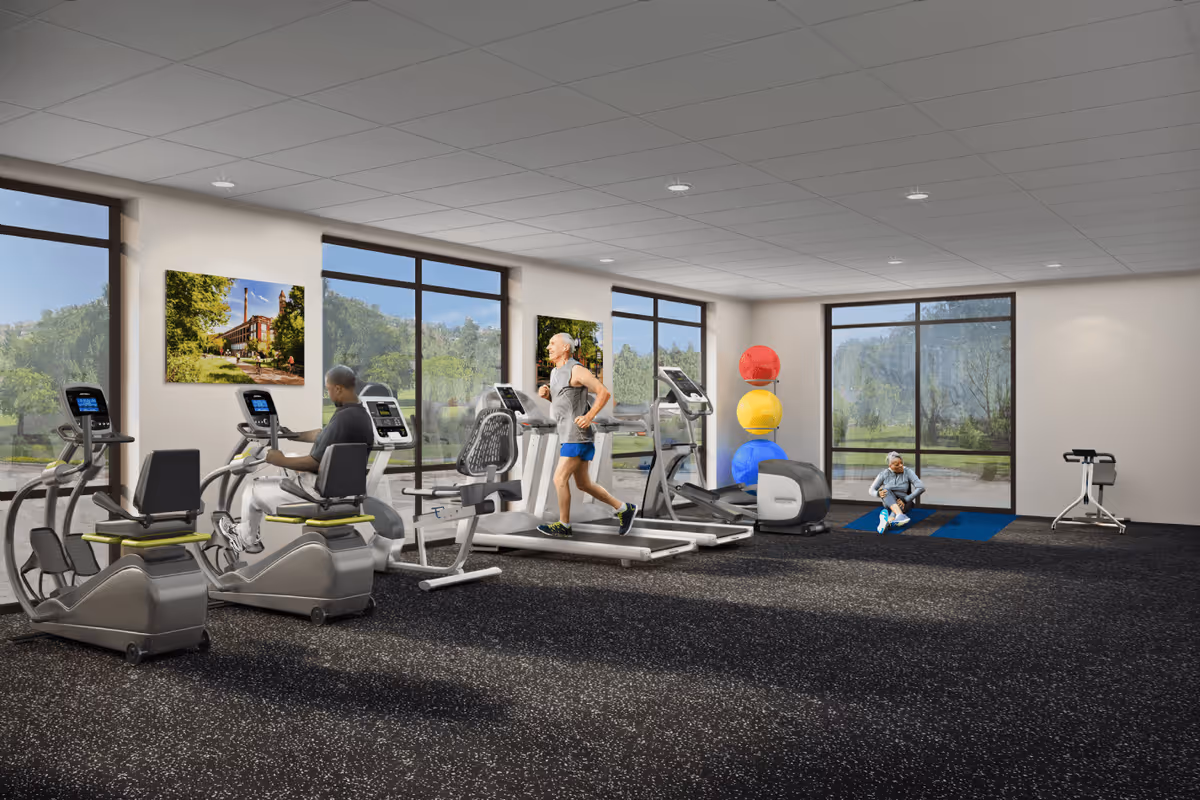 A fitness room with large windows showing greenery outside. Inside, there are exercise machines including stationary bikes and treadmills. Three elderly individuals are using the equipment or stretching on mats. Colorful exercise balls are stacked in the corner.