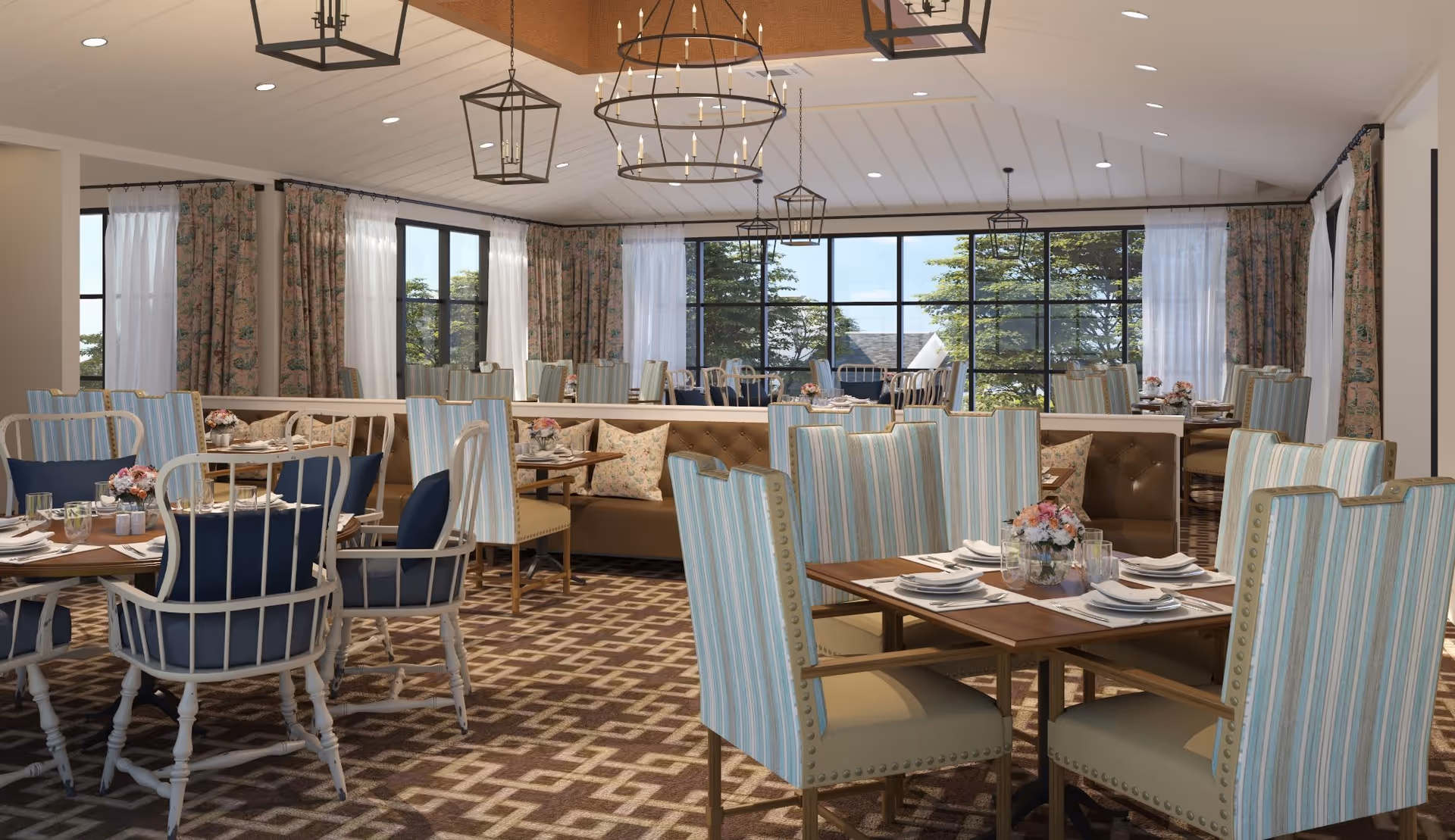 Spacious dining room with set tables, striped upholstered chairs, chandeliers, and large windows overlooking trees.
