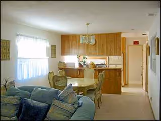 Cozy interior of a senior living space with a sofa, dining table, and kitchen.
