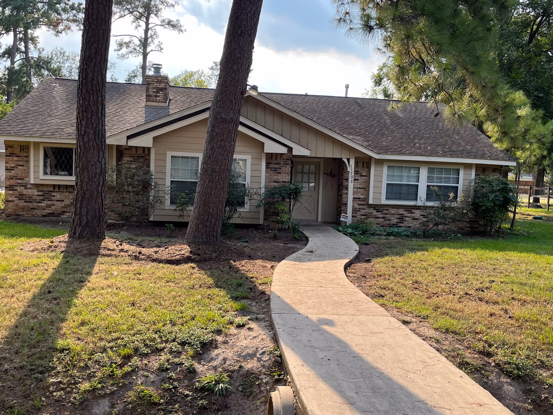 Front exterior of a single-story home with a curved walkway to the entrance.