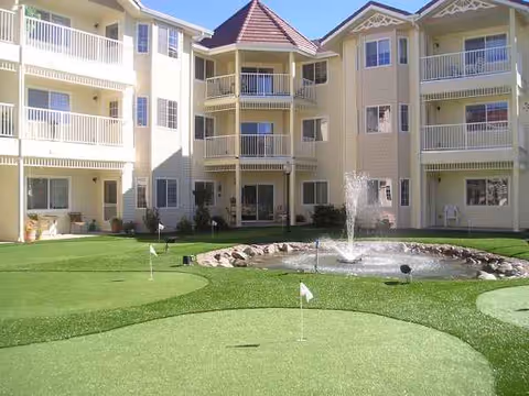 Courtyard at a senior living building featuring a fountain and putting green