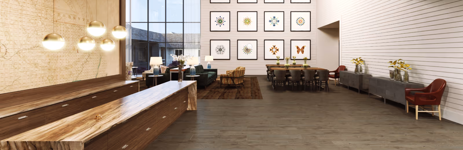 Spacious modern common area with a long wooden reception counter, seating lounge, dining table, framed wall art and large windows.