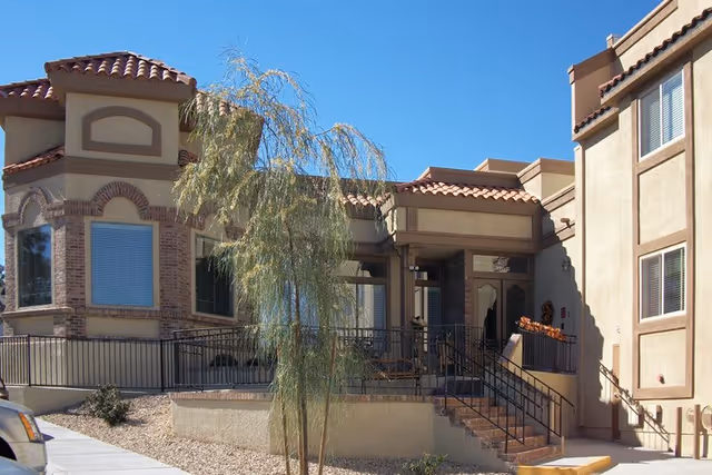 Exterior view of Lakeview Terrace Retirement Community's beige building with stairs and landscaping.