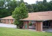 Exterior view of a single-story brick assisted living facility with a covered entrance.