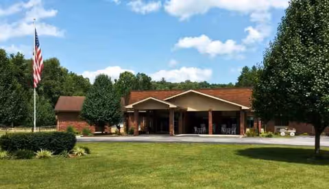 Front view of Huntsville Post-Acute and Rehabilitation Center with brick exterior and flag.
