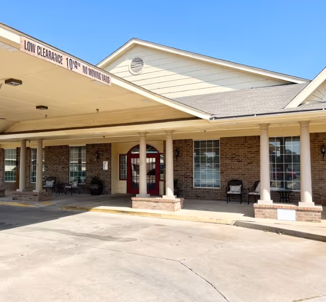 Brick assisted living facility entrance with a covered front porch and columns.